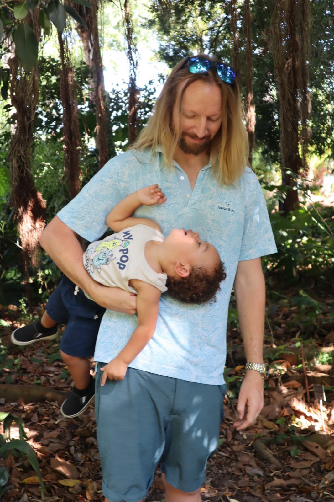 Tampa family session of a parent and child laughing together in a wooded park